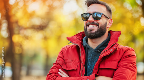 Smiling man in red jacket with sunglasses in fall foliage.