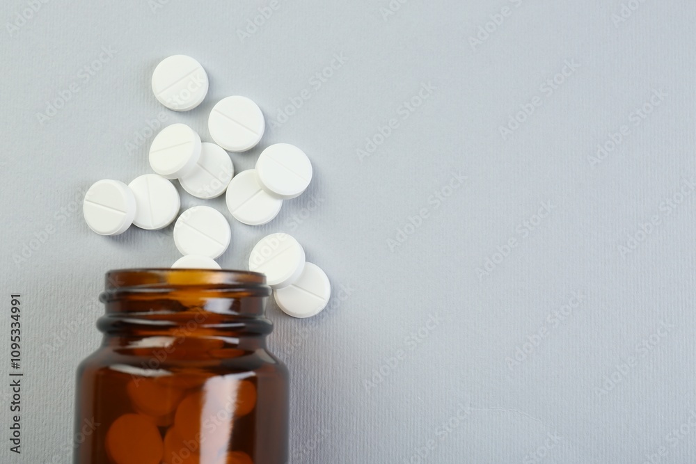 Medical bottle with antibiotic pills on grey background, top view. Space for text Medical bottle with antibiotic pills on grey background, top view. Space for text