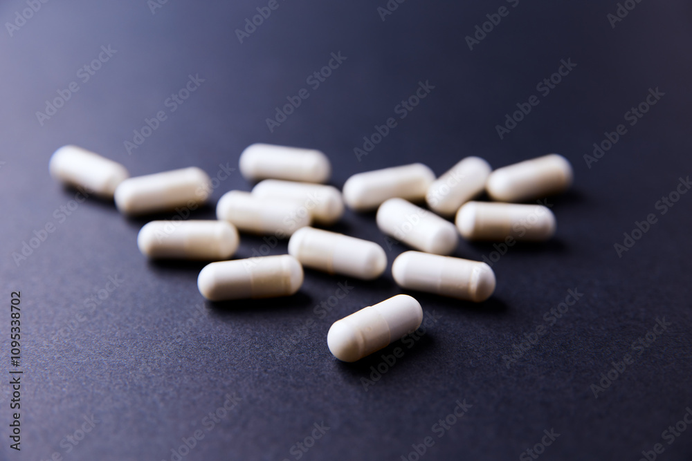 Creatine capsules on dark paper background. Soft focus. Copy space. Creatine capsules on dark paper background. Soft focus. Copy space.