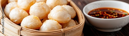 Golden Fried Mushrooms Presenting a Delicious Meal in a Bamboo Basket Next to a Small Bowl of Spicy Dipping Sauce on a Wooden Surface for Culinary Delight