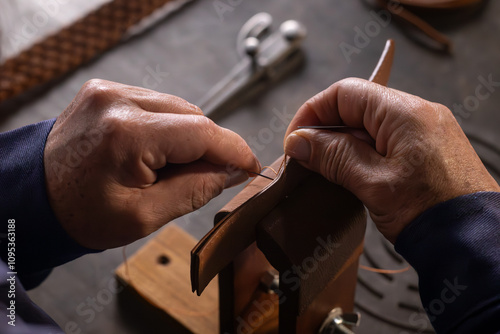 craftsman sewing leather by hand