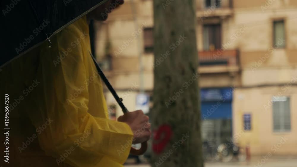 Business man tourist person with umbrella and raincoat on rainy european city street, lights reflecting, walking in Barcelona or Amsterdam during the rain. Business man tourist person with umbrella and raincoat on rainy european city street, lights reflecting, walking in Barcelona or Amsterdam during the rain.