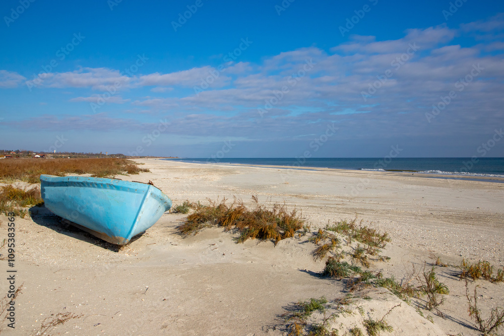 Landscape with an old fishing boat on the sand at the seaside Landscape with an old fishing boat on the sand at the seaside
