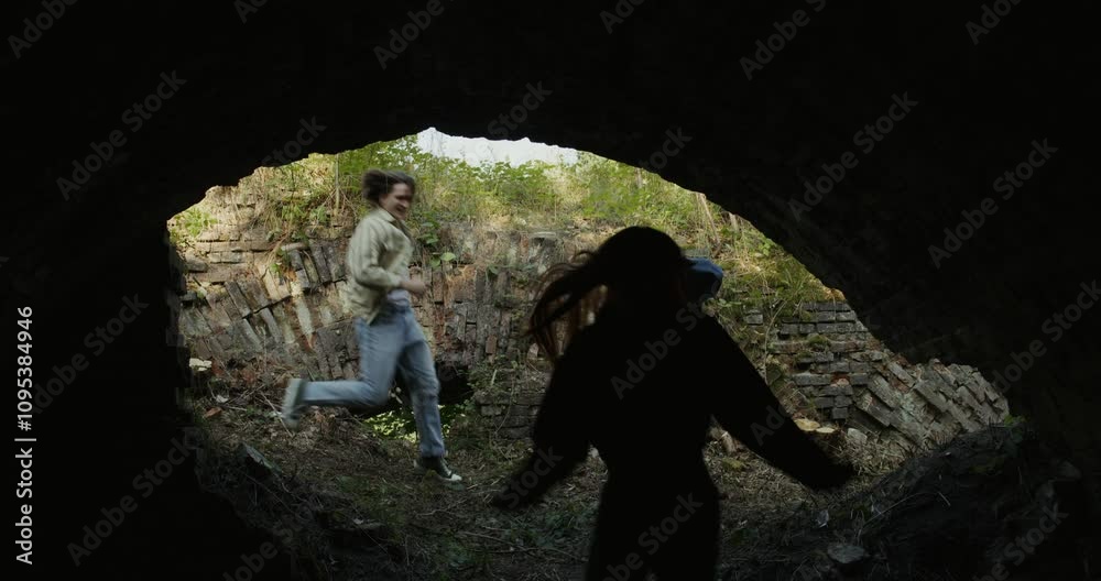 Three friends run into the basement of a destroyed building. The view from the inside Three friends run into the basement of a destroyed building. The view from the inside