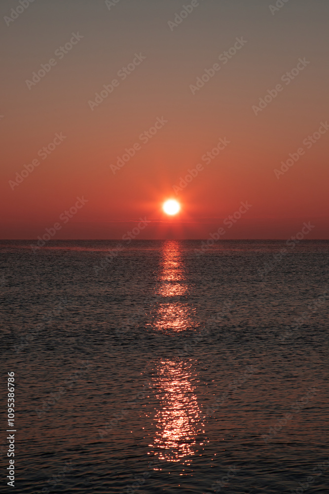 Landscape with a spectacular sunset at sea with sunlight reflected in the water Landscape with a spectacular sunset at sea with sunlight reflected in the water