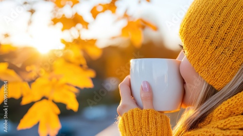 A serene moment as a woman enjoys a steaming cup of coffee, nestled in autumn's gold leaves, capturing a stillness and quietude amidst vibrant hues. photo