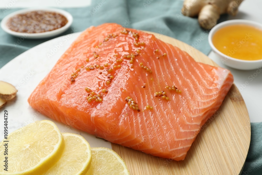 Salmon fillet with mustard and lemon slices on table, closeup Salmon fillet with mustard and lemon slices on table, closeup