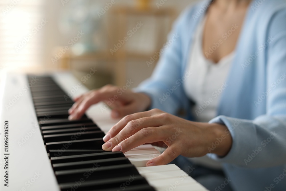 Obraz premium Woman playing synthesizer indoors, closeup. Electronic musical instrument