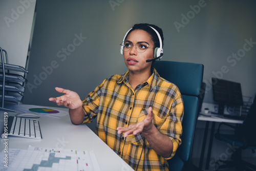 Photo of young woman confused answer question client call center wear yellow plaid shirt comfortable office room interior indoors workspace