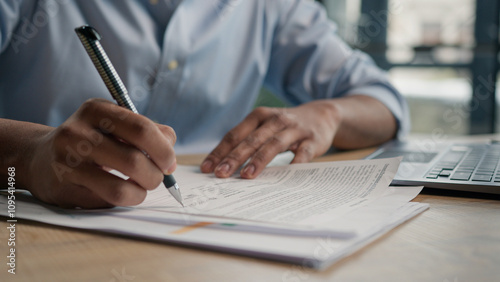 Close up unrecognizable man businessman writing paperwork report on desktop male hands signing business documents on office table student write educational test english exam studying in university  photo