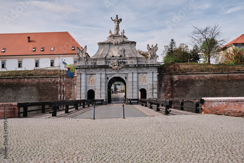 Majestic stone archway of a historic fortress, adorned with statues and intricate details. Cobblestone path leads to the imposing entrance. A perfect blend of history and architecture. alba iulia photo