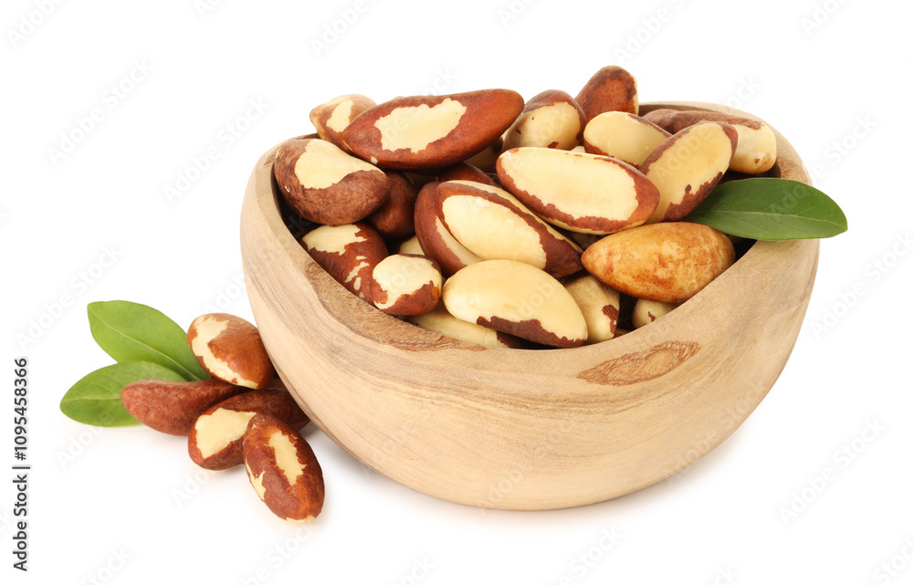 Fototapeta premium Tasty Brazil nuts and green leaves in bowl isolated on white