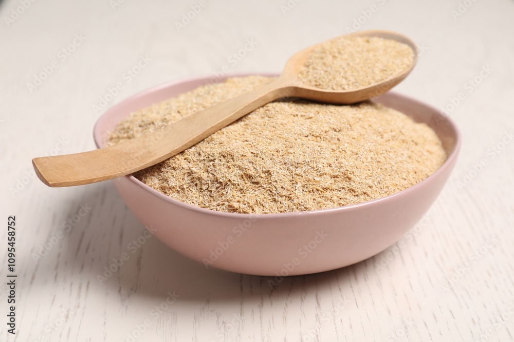 Oat bran in bowl and spoon on light wooden table, closeup Oat bran in bowl and spoon on light wooden table, closeup