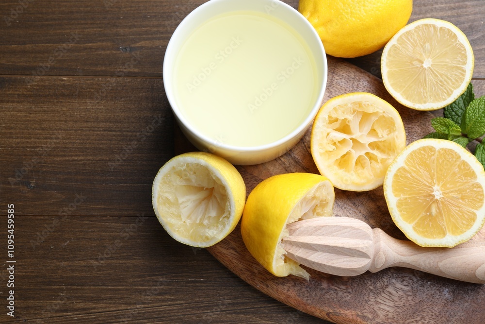 Squeezer, lemons, mint and juice on wooden table, top view. Space for text Squeezer, lemons, mint and juice on wooden table, top view. Space for text
