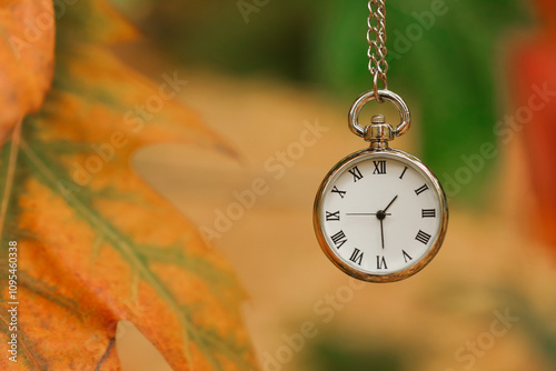 Autumn time. Chain watch on blurred background, closeup with space for text