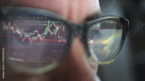 Businessman analyzing stock market data reflected in glasses showcases a focused approach to understanding market trends and financial strategies through visual data interpretation