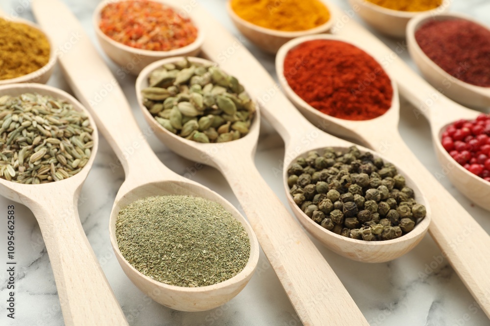 Different aromatic spices in spoons on white marble table, closeup Different aromatic spices in spoons on white marble table, closeup