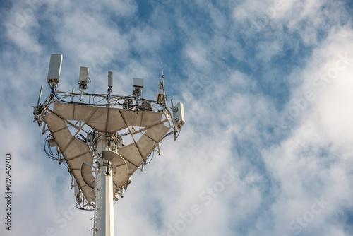 5g mobile network communication tower with cellular antenna transmitter and receiver, broadcasting 4g lte equipment, phone network station on sky with clouds background