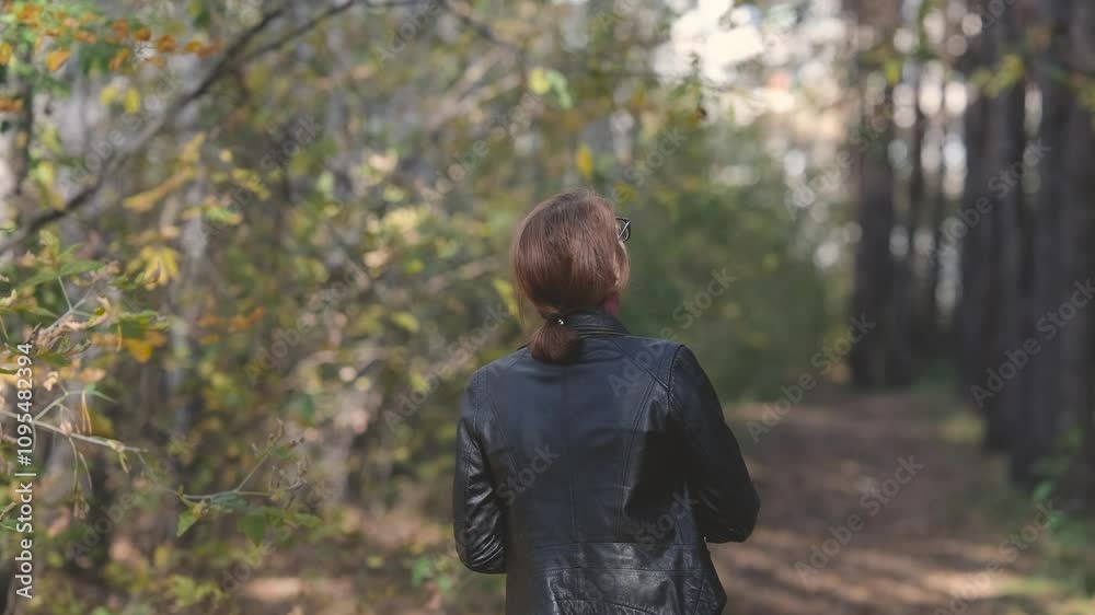 Smiling city woman relaxing in the forest. Thoughtful woman in glasses and office clothes walking in the autumn park, breathing fresh air, enjoying nature. Smiling city woman relaxing in the forest. Thoughtful woman in glasses and office clothes walking in the autumn park, breathing fresh air, enjoying nature.
