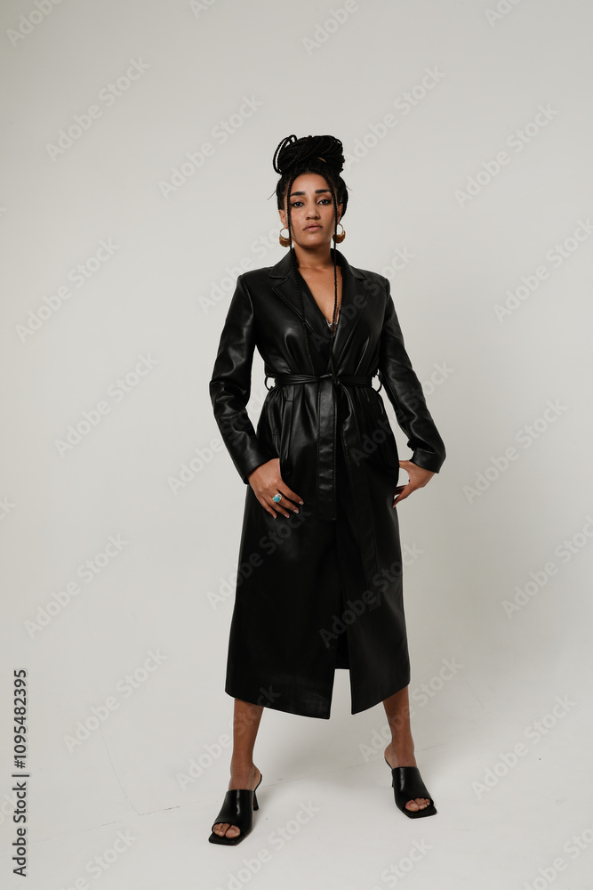 Confident African American pretty woman with long dark braids staying over white background. Confident African American pretty woman with long dark braids staying over white background.
