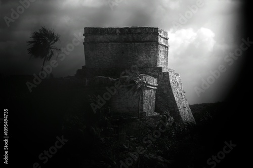 Silhouette of majestic Mayan temple behind foliage, medium shot 