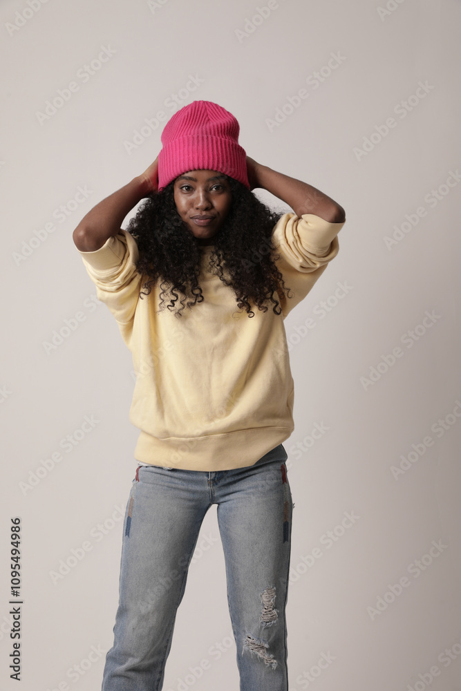 Lovely and optimistic teenage girl with dark skin long afro hair poses against white background dressed in casual clothes. Lovely and optimistic teenage girl with dark skin long afro hair poses against white background dressed in casual clothes.