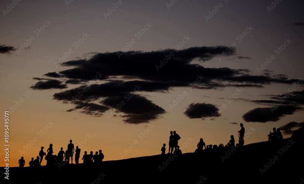 Silhouette of groups of people on hillside at dusk Silhouette of groups of people on hillside at dusk