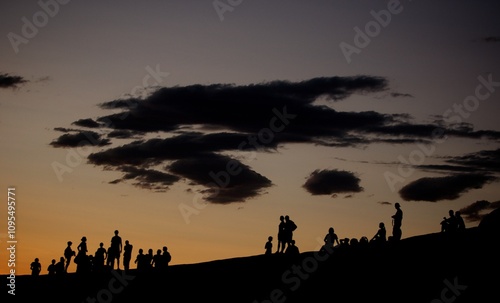 Silhouette of groups of people on hillside at dusk