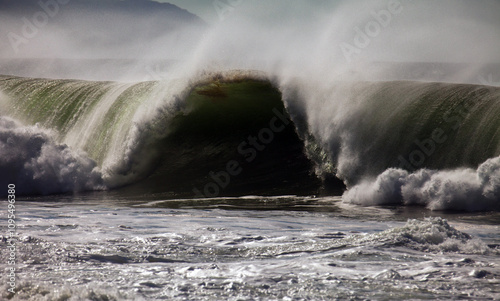 Spraying ocean wave in mid roll, medium shot photo