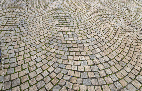 Full frame abstract texture background of a European cobblestone courtyard surface with gray and beige stones