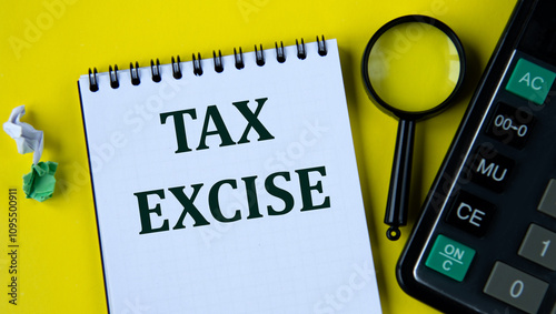 TAX EXCISE - words in a white notebook with a calculator and a magnifying glass on a yellow plan
