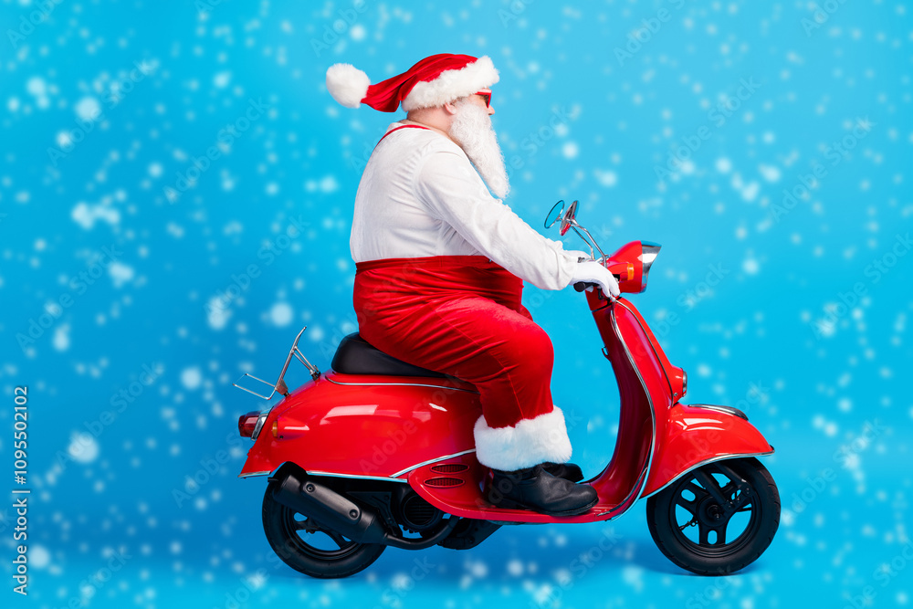 Full length profile side photo of fat santa claus with big beard drive scooter x-mas christmas newyear wear stylish modern suspenders overalls hat isolated blue color background Full length profile side photo of fat santa claus with big beard drive scooter x-mas christmas newyear wear stylish modern suspenders overalls hat isolated blue color background