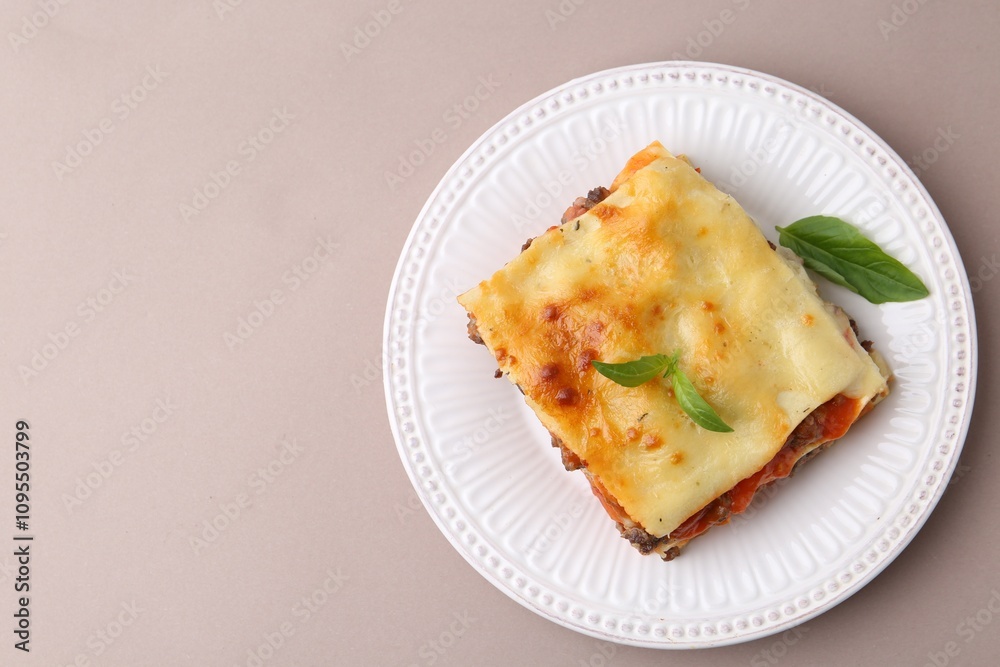 Delicious cooked lasagna with basil on light grey table, top view. Space for text Delicious cooked lasagna with basil on light grey table, top view. Space for text