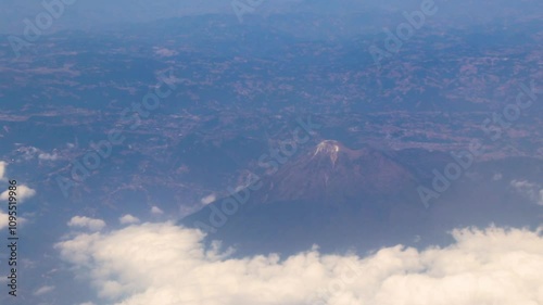 Flying airplane over Mexico clouds sky vlcanoes mountains desert landscape. photo