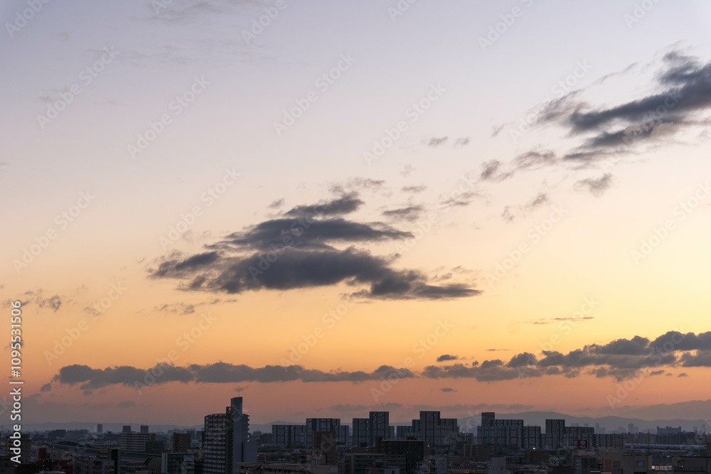 Fototapeta premium 都市の夜明け。高層ビルをシルエットにあたりはオレンジ色に染まる