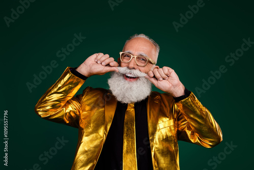 Charismatic elderly man in a golden suit with glasses celebrates with joy against a green background