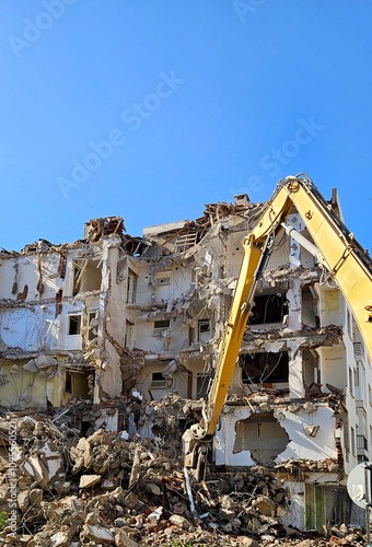 Demolition of building. Excavator breaks old house. long armed demolition machine seen demolishing a building.