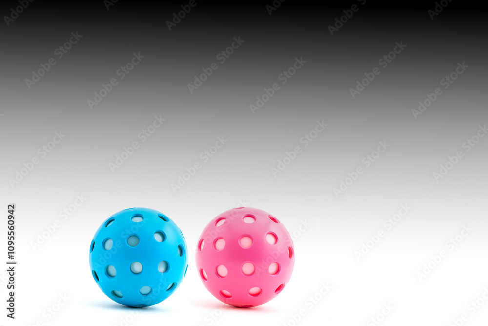 Blue and Pink Pickleballs on a gradated background. Blue and Pink Pickleballs on a gradated background.