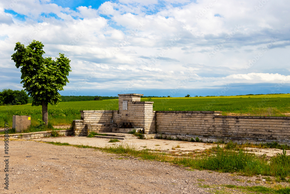 Fototapeta premium Roadside fountain between the village of Krum and the town of Dimitrovgrad in Haskovo Province, Southern Bulgaria against a beautiful spring landscape