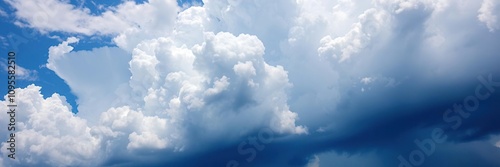 A dramatic display of fluffy white clouds against the deep blue color of the sky with a hint of thunder, dramatic skies, blue sky