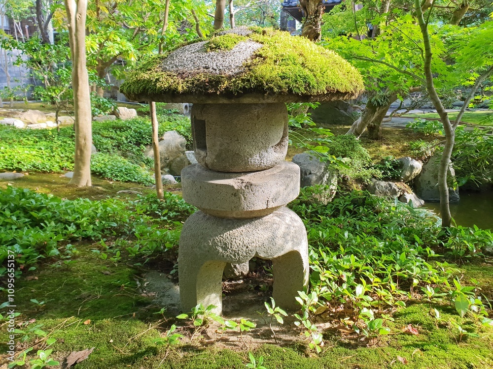 Japanese stone lantern. A stone lantern sits in a very beautiful and green Japanese garden. Japanese stone lantern. A stone lantern sits in a very beautiful and green Japanese garden.