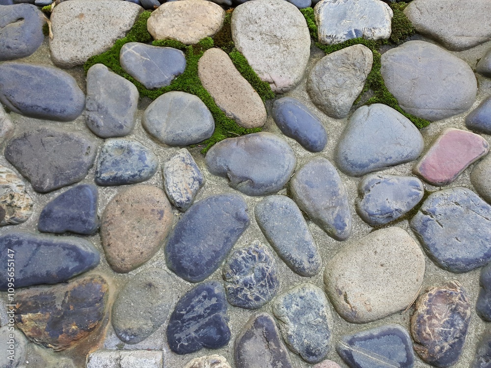 Gray stone wall texture. Textured gray stone wall made by small rounded pebbles Gray stone wall texture. Textured gray stone wall made by small rounded pebbles