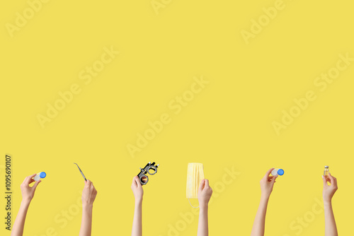 Hands with lenses, thermometer, medical mask and trial optical frame on yellow background