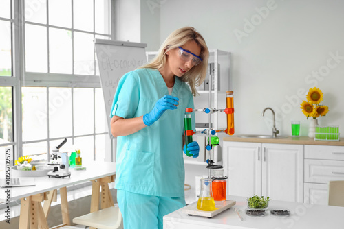 Female scientist with flasks of samples, sunflower seeds and sprouts working in laboratory