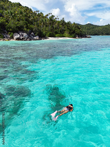 Indonesia Anambas Islands - Drone view reef with female snorkeller vertical