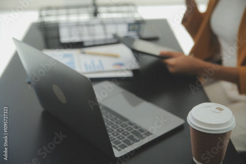 Close up Business woman using calculator and laptop for do math finance on wooden desk, tax, accounting, statistics and analytical research concept