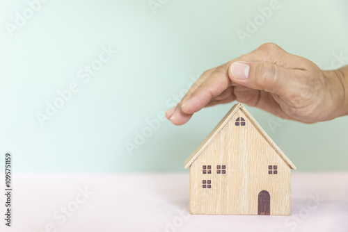 Hand protect house for plan of money savings or financial planning for home loan management for buy housing residential or family insurance or banking agreement.