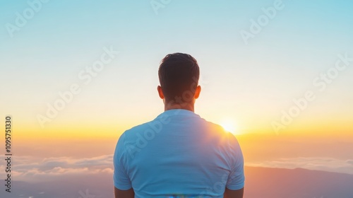 A man is standing on a mountain and looking at the sun