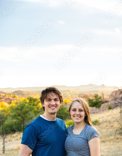 Couple enjoys a joyful moment outdoors in a scenic landscape during golden hour