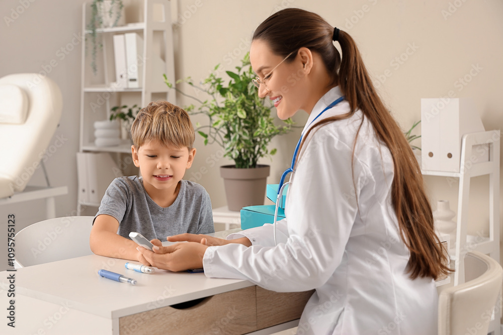 Little diabetic boy with doctor using glucometer at table in clinic Little diabetic boy with doctor using glucometer at table in clinic